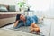 Playing with cat at home. Young woman lying on carpet and teasing pet