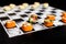 Playing chess with Japanese sushi roll pieces without rice on chalkboard background.  Asian sushi with salmon, tuna, cream cheese,