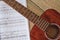 Playing Guitar. Close up view of brown acoustic guitar with music notes against wooden floor