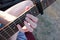 Playing guitar close up. A woman`s hand clamps the strings of a guitar.