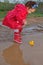 Playing with her water toys on muddly puddles