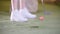 Playing mini golf. A person in white sneakers hitting the golf ball and misses