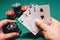 Playing poker in the casino. Cards with two pairs in the hand of the player making a bet with chips