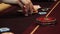 Playing poker. Woman is nervous, fingering the chips in her hand on the poker table. Hand close up. Casino gamble.