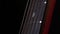 Playing strings of acoustic guitar, down view, third string, on black, close up, slow motion