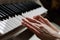 Playing on the synthesizer close-up. women`s hands on the keys