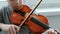 Playing the violin. Unrecognizable seven years old boy playing the violin closeup. Front view.