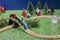 playing with wooden toy train on grren background. Wooden toy railway and kid& x27;s face. Concept of the childhood, children