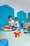 Playtime at nursery school. Toddlers caucasian boys sitting on the floor and playing with colorful plastic cars, boats