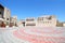 A Plaza with a coffee shop. Ancraient arabic air cooling towers and buildings. Dubai, United Arab Emirates.UAE