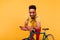 Pleasant african man with curly hair standing beside bicycle. Indoor shot of ecstatic black guy pos