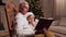 Pleasant aged man reading a book with his little grandson