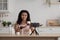 Pleasant attractive mixed race female professional holding jar, make video ad in blog