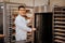 Pleasant baker standing near big oven in the kitchen