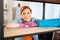 Pleasant beaming mature female leaning on wooden shelf