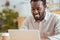 Pleasant cheerful man smiling while working on laptop