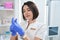 Pleasant clinic employee holds bottle of medicine in her hands