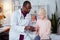 Pleasant dark-skinned pediatrician giving little girl some pills