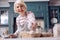 Pleasant elderly woman taking egg while making dough