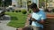 Pleasant Indian man sitting outdoors and using camera