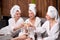 Pleasant ladies enjoy drinking champagne at spa. Three beautiful women wearing bathrobes having cool resting, holidays