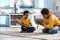 Pleasant little boys playing with toy dinosaurs on floor