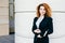 Pleasant-looking curly woman dressed formally, holding notebook in hands, going to have meeting wit her business partners. Gorgeou