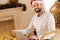 Pleasant man in Santa hat posing with laptop