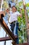 Pleasant preteen boy making steps along rope trail