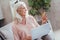 Pleasant retired woman using online banking at home