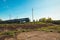 Pleasant summer landscape: old blue sky and clouds, green grass and trees, railway path road, old rusty industrial metal