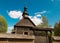 Pleasant sunny summer landscape: old blue sky and clouds, green trees and old historical Slavic Orthodox country church building