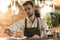 Pleasant young barman cleaning bar counter with cloth