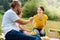 Pleasant young family sharing food on picnic