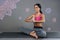 Pleasant young woman smiling while doing yoga exercises