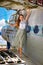 Pleasant young woman stands on the wing of an abandoned plane