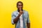 Please, keep silence. Portrait of cheerful handsome man gesturing to be quiet. indoor studio shot isolated on yellow background