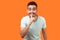 Please, keep silence! Portrait of positive brunette man asking to be quiet. indoor studio shot isolated on orange background