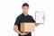 Please sign here to get your box. Cheerful young deliveryman holding carton box and clipboard while isolated on white
