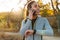 Pleased african american sportswoman talking on cellphone while using smartwatch