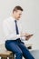 Pleased attractive young businessman checks email on portable pc, watches vidio on internet webpage, uses free internet connection