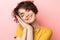 Pleased beautiful woman posing isolated over pink wall background ready to sleep