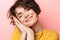 Pleased beautiful woman posing isolated over pink wall background ready to sleep