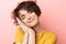 Pleased beautiful woman posing  over pink wall background ready to sleep