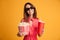 Pleased brunette woman in dress and eyeglasses preparing to watch