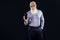 Pleased elderly handsome senior businessman with white beard holding mobile phone with blank empty screen, showing device to the