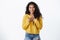 Pleased and flattered cute smiling african american curly-haired girl, wear yellow cozy sweater, press hands to chest