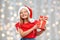 Pleased girl in santa hat with christmas gift