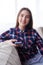 Pleased girl sitting on sofa with telephone