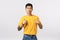 Pleased handsome arrogant asian guy in yellow t-shirt, pointing himself and smiling, employee promoting own abilities